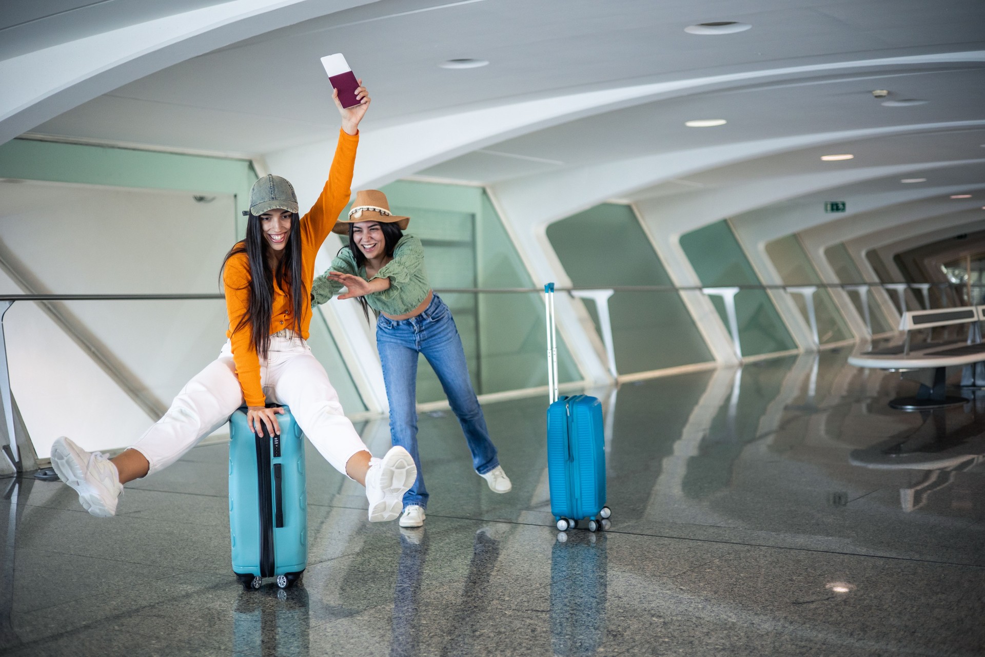 Deux amis multiculturels s’amusent avec leurs bagages à l’aéroport avec un passeport en main